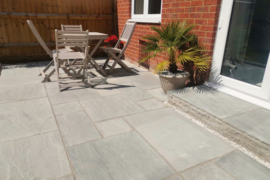 This is an example of a contemporary back patio in Oxfordshire with no cover.
