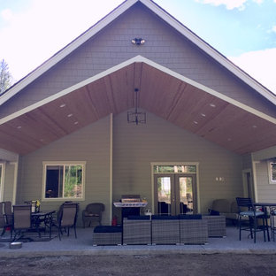 Immagine di un grande patio o portico stile americano dietro casa con lastre di cemento e un tetto a sbalzo