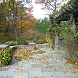 Foto di un ampio patio o portico country dietro casa con pavimentazioni in pietra naturale