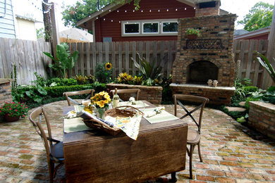 Diseño de patio tradicional grande sin cubierta en patio trasero con adoquines de ladrillo y brasero