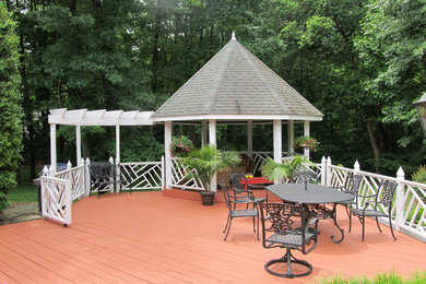 Modelo de patio clásico grande en patio trasero con entablado y cenador