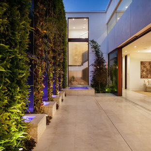 Patio fountain - mid-sized contemporary backyard tile patio fountain idea in Orange County with no cover