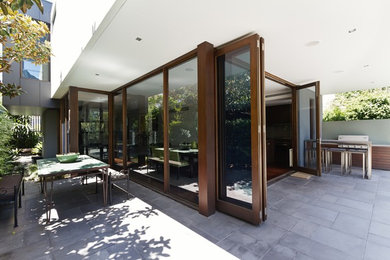 Свежая идея для дизайна: большой двор на заднем дворе в современном стиле с летней кухней, мощением тротуарной плиткой и навесом - отличное фото интерьера