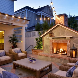 Idee per un piccolo patio o portico stile marinaro dietro casa con un focolare, piastrelle e nessuna copertura