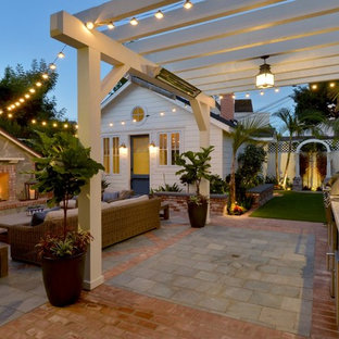 Foto di un piccolo patio o portico stile marino dietro casa con pavimentazioni in mattoni e una pergola