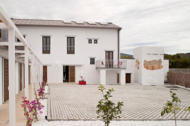 Diseño de patio mediterráneo grande en patio con gravilla y pérgola