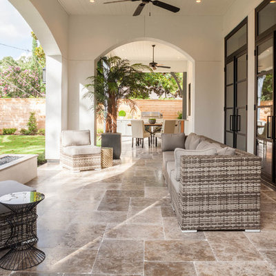 Example of a transitional backyard tile patio design in Houston with a fire pit and a roof extension