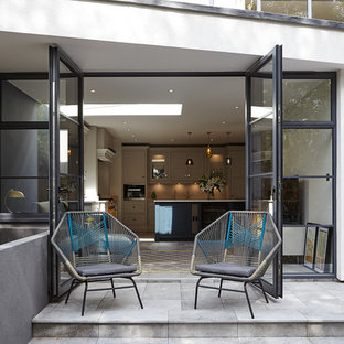 Inspiration for a contemporary back patio in London with concrete paving and no cover.