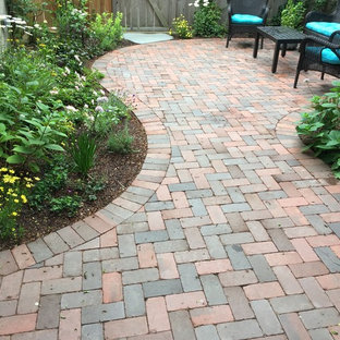 Idee per un patio o portico tradizionale di medie dimensioni e dietro casa con pavimentazioni in mattoni e nessuna copertura
