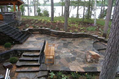 Inspiration for a large rustic stone patio remodel in Toronto with no cover