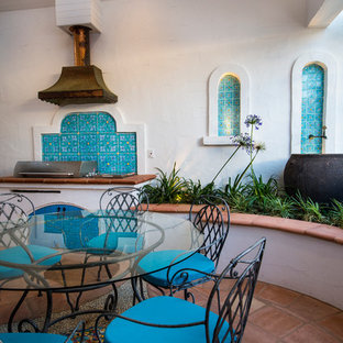 Esempio di un piccolo patio o portico mediterraneo in cortile con piastrelle