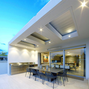 Idee per un patio o portico minimal con un tetto a sbalzo e piastrelle
