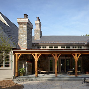 Esempio di un grande patio o portico country dietro casa con pavimentazioni in pietra naturale e una pergola