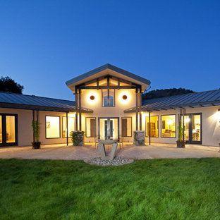 Ispirazione per un grande patio o portico american style dietro casa con un focolare, pavimentazioni in mattoni e un parasole