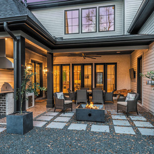 Esempio di un grande patio o portico moderno dietro casa con un focolare, un tetto a sbalzo e graniglia di granito