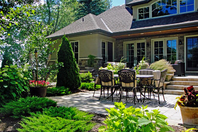 Patio - mid-sized traditional backyard stone patio idea in Toronto with no cover