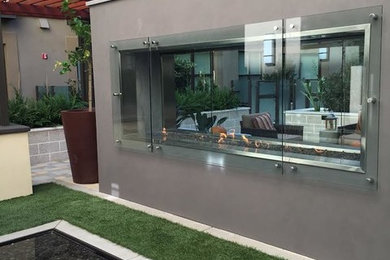 Example of a mid-sized trendy courtyard concrete patio design in San Francisco with a fire pit and no cover