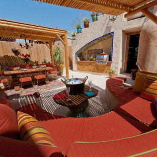 Idee per un ampio patio o portico eclettico dietro casa con pavimentazioni in pietra naturale e una pergola