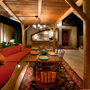 Foto di un ampio patio o portico eclettico dietro casa con pavimentazioni in pietra naturale e una pergola