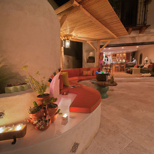 Immagine di un ampio patio o portico bohémian dietro casa con pavimentazioni in pietra naturale e una pergola