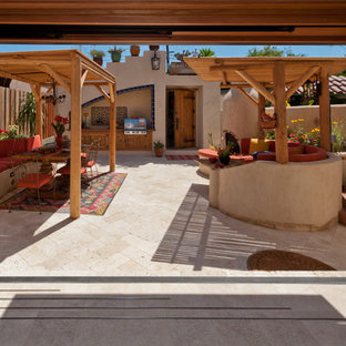 Foto di un ampio patio o portico boho chic dietro casa con pavimentazioni in pietra naturale e una pergola