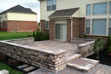 Patio - mid-sized contemporary courtyard stone patio idea in Detroit with a fire pit
