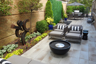 Modelo de patio contemporáneo de tamaño medio sin cubierta en patio trasero con brasero y losas de hormigón