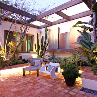 Island style patio photo in Orange County with a pergola