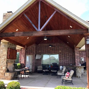 Ispirazione per un patio o portico stile americano di medie dimensioni e dietro casa con pavimentazioni in cemento e un tetto a sbalzo