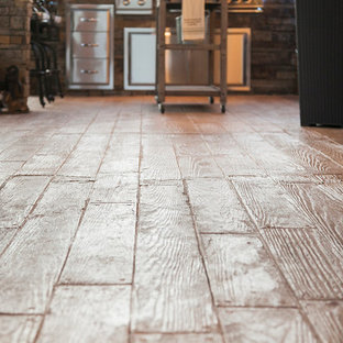 Esempio di un patio o portico stile rurale di medie dimensioni e dietro casa con cemento stampato e un tetto a sbalzo