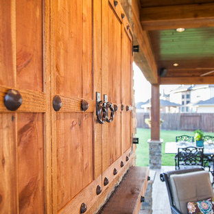 Ispirazione per un patio o portico rustico di medie dimensioni e dietro casa con cemento stampato e un tetto a sbalzo