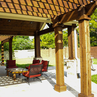 Foto di un patio o portico tradizionale di medie dimensioni e dietro casa con un focolare, cemento stampato e una pergola