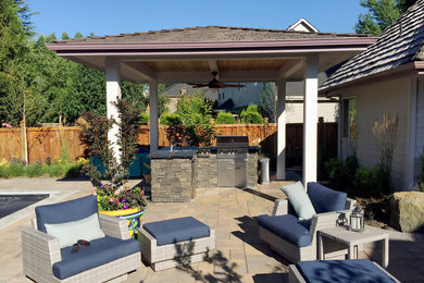 Foto de patio tradicional de tamaño medio en patio trasero con cocina exterior, adoquines de hormigón y cenador
