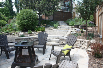 Inspiration for a mid-sized timeless backyard concrete paver patio remodel in Calgary with a fire pit and no cover