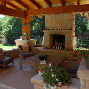 Esempio di un patio o portico stile americano di medie dimensioni e dietro casa con un focolare, pavimentazioni in pietra naturale e un gazebo o capanno