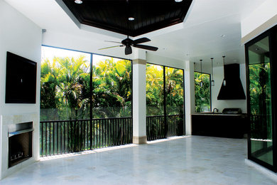 Example of a large transitional backyard tile patio kitchen design in Miami with a roof extension