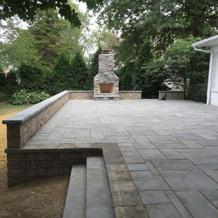 Ispirazione per un patio o portico american style di medie dimensioni e dietro casa con cemento stampato, nessuna copertura e un focolare