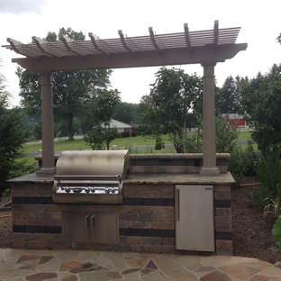 Idee per un grande patio o portico stile americano dietro casa con pavimentazioni in mattoni e una pergola