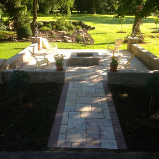 Esempio di un patio o portico american style di medie dimensioni e dietro casa con un focolare, cemento stampato e nessuna copertura