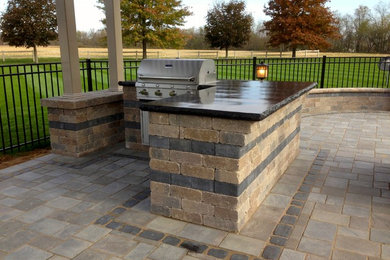 Large arts and crafts backyard brick patio kitchen photo in Cleveland with a pergola
