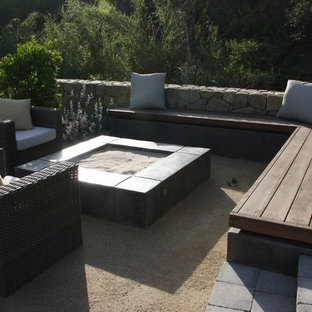 Esempio di un patio o portico country di medie dimensioni e dietro casa con un focolare, pavimentazioni in pietra naturale e nessuna copertura