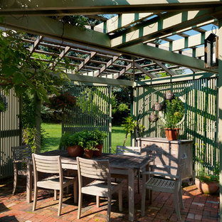 Immagine di un patio o portico country in cortile con una pergola