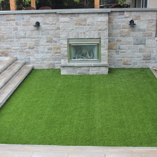 Ispirazione per un grande patio o portico contemporaneo dietro casa con un focolare, cemento stampato e una pergola