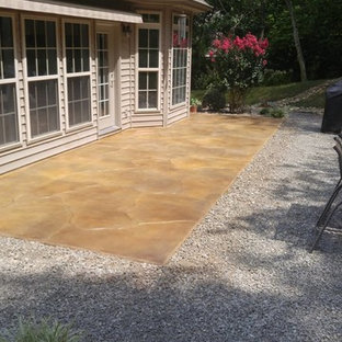 Esempio di un patio o portico chic di medie dimensioni e dietro casa con cemento stampato e nessuna copertura