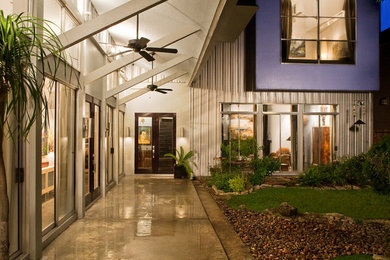 Immagine di un patio o portico contemporaneo di medie dimensioni e dietro casa con un parasole e lastre di cemento