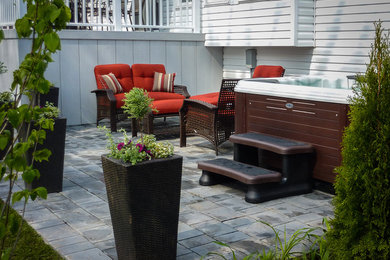 Photo of a large contemporary back patio in Toronto with a water feature, natural stone paving and no cover.