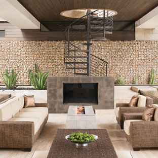 Idee per un ampio patio o portico minimal dietro casa con un focolare e un tetto a sbalzo
