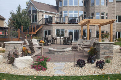 Diseño de patio extra grande en patio trasero con brasero, adoquines de ladrillo y pérgola