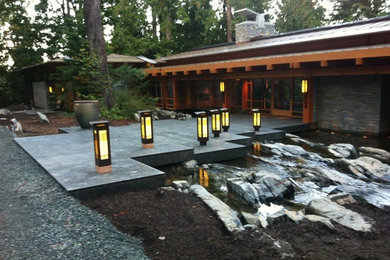 Imagen de patio de estilo zen grande sin cubierta en patio lateral con adoquines de piedra natural