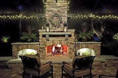 Example of a large trendy backyard brick patio design in Other with a fire pit and a gazebo